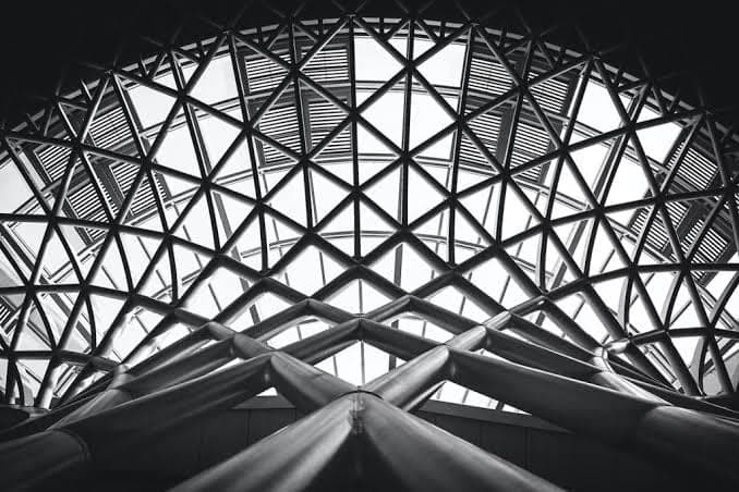 A triangulated steel space frame seen from below.
