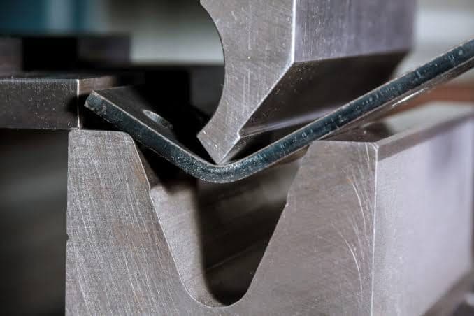 A press brake forming a steel section.