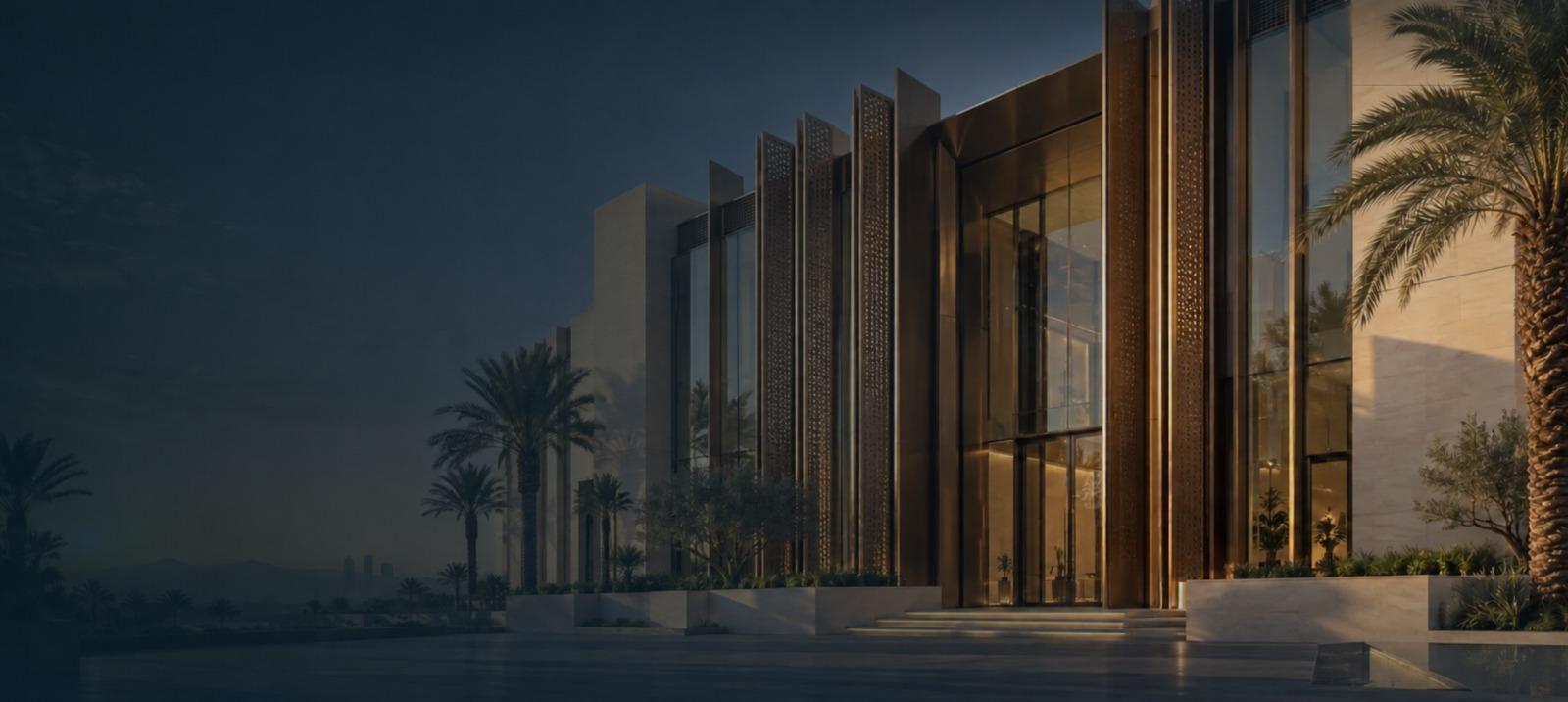 A landmark facade at dusk, clad in bronze metal fins and full-height glazing, framed by palms.