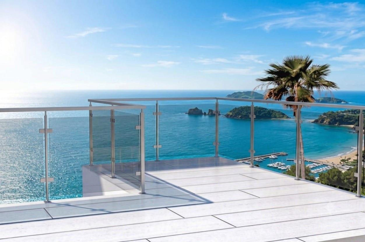 A glass balustrade along a seafront terrace at sunset.